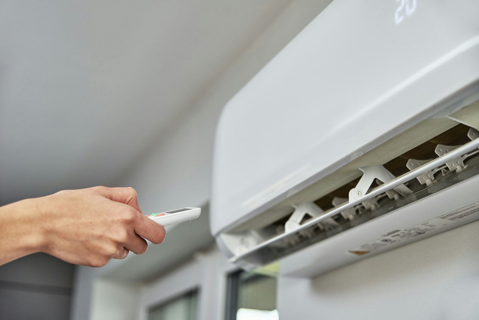 Hand adjusting temperature on air conditioner