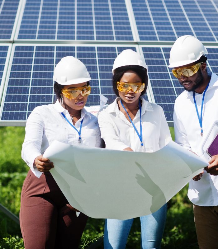 African american technician checks the maintenance of the solar panels. Group of three black engineers meeting at solar station.