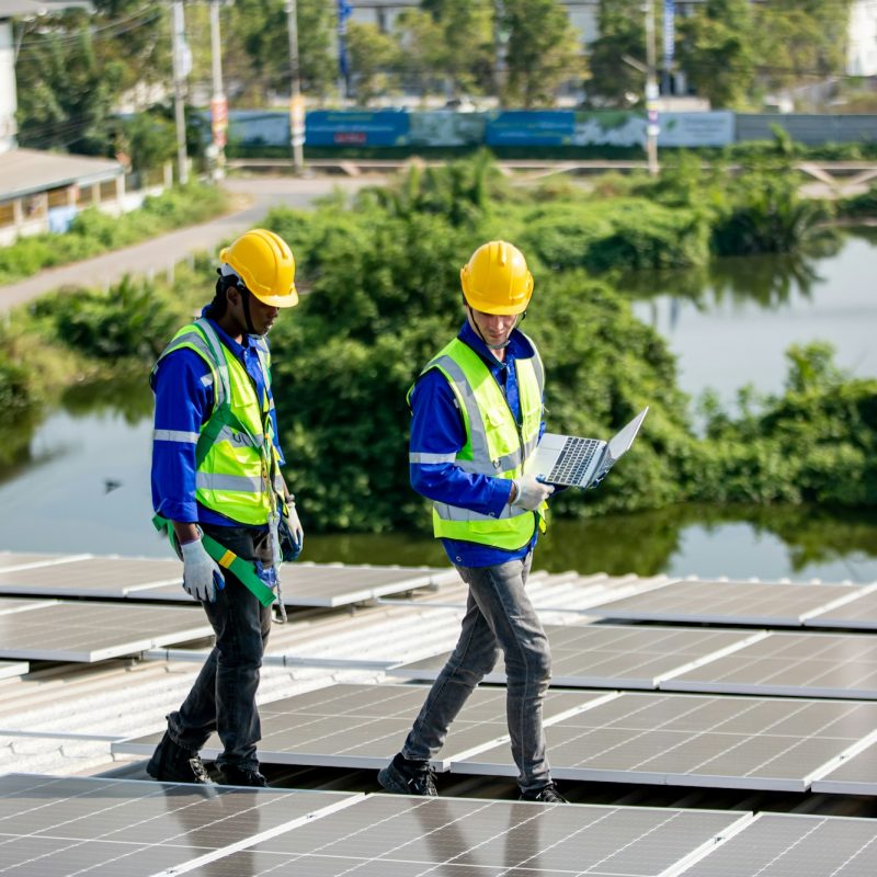 Solar panel installer installing solar panels on roof of warehouse optimiser vos économies d'énergie en Guadeloupe